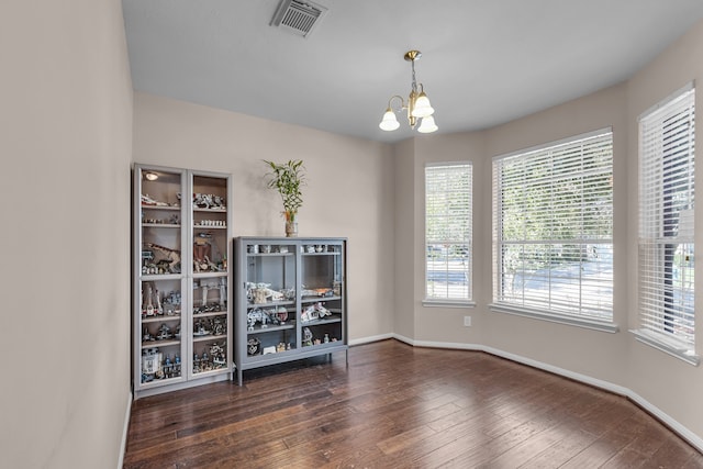 empty room featuring dark hardwood / wood-style floors and a notable chandelier