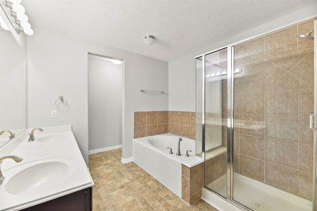 bathroom featuring vanity, a textured ceiling, and plus walk in shower