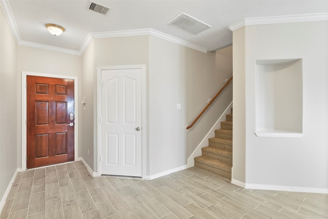 foyer featuring light wood-type flooring and crown molding