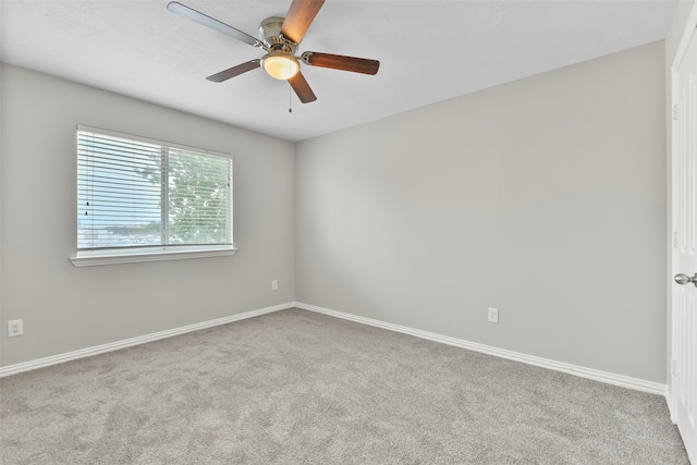 spare room with ceiling fan and light colored carpet