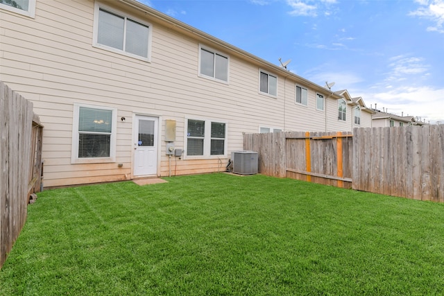 back of property featuring a lawn and central air condition unit