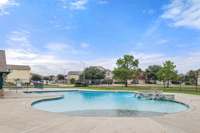 view of swimming pool featuring pool water feature and a patio area