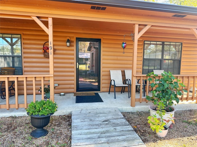 view of exterior entry featuring covered porch