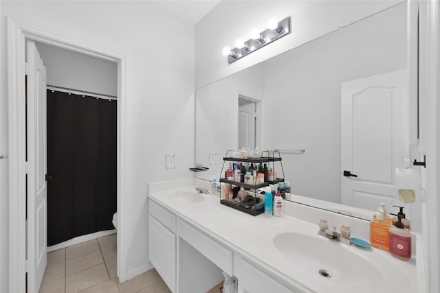 bathroom with tile patterned flooring, vanity, and toilet