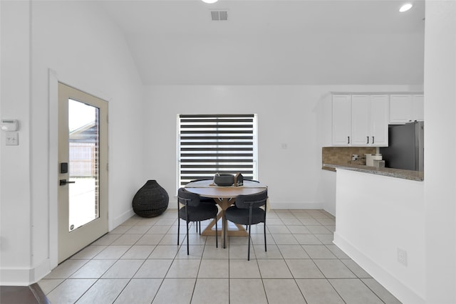 tiled dining area featuring a wealth of natural light and vaulted ceiling