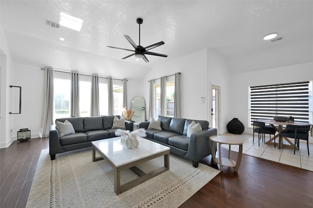 living room featuring ceiling fan, dark hardwood / wood-style flooring, a textured ceiling, and vaulted ceiling