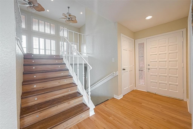 staircase featuring ceiling fan and wood-type flooring