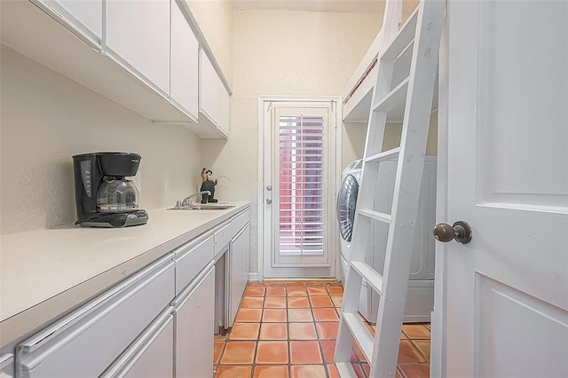 washroom featuring washer / clothes dryer, sink, and light tile patterned floors