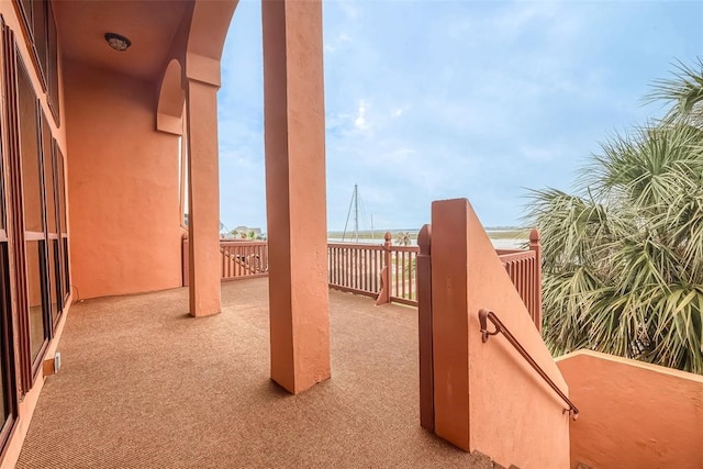 view of patio featuring a balcony and a water view