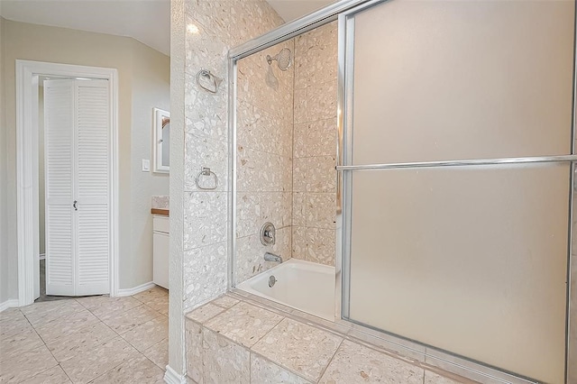 bathroom with tile patterned flooring, vanity, and combined bath / shower with glass door