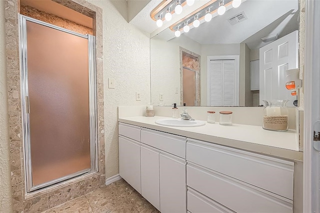 bathroom with vanity and a shower with shower door