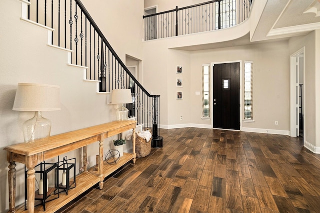 foyer with a towering ceiling and dark hardwood / wood-style floors