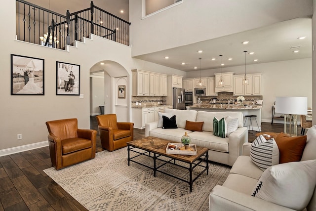 living room with hardwood / wood-style floors and a towering ceiling