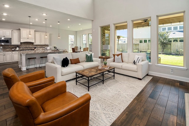 living room with a wealth of natural light, hardwood / wood-style floors, and a high ceiling