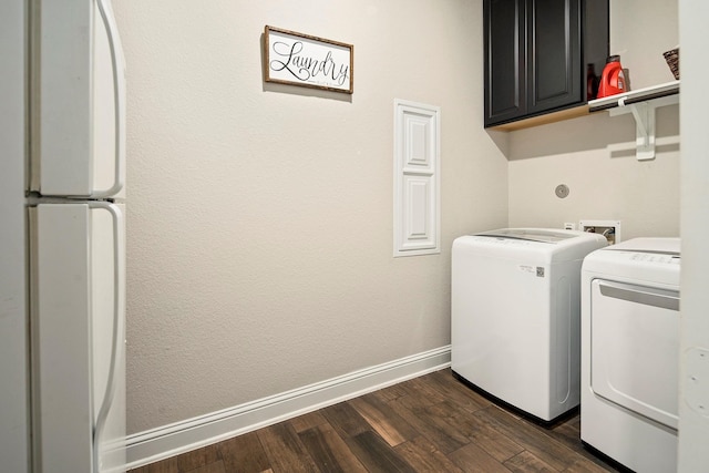 washroom featuring washer and dryer, cabinets, and dark wood-type flooring