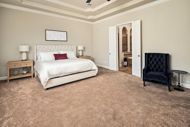 bedroom with carpet flooring, ensuite bathroom, ornamental molding, a raised ceiling, and ceiling fan