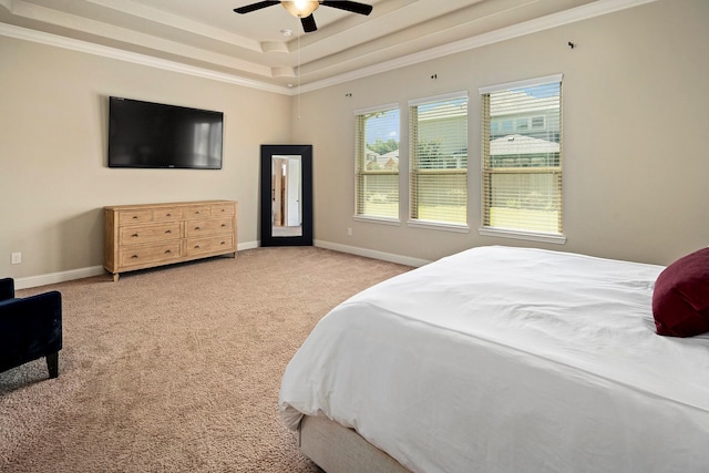 bedroom featuring light carpet, a tray ceiling, ceiling fan, and ornamental molding