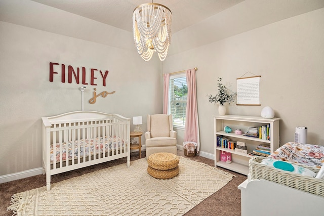 bedroom featuring carpet floors, a crib, and a notable chandelier