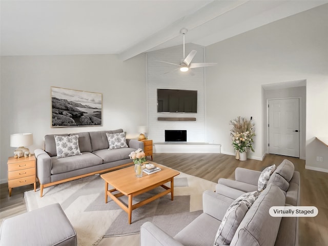 living room featuring vaulted ceiling with beams, a large fireplace, light wood-type flooring, and ceiling fan