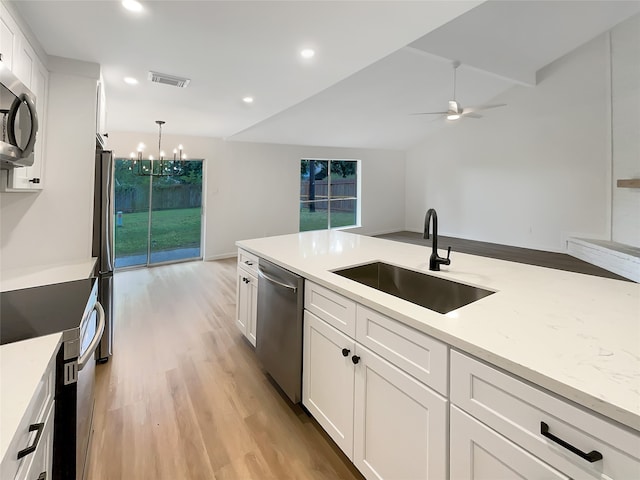 kitchen with appliances with stainless steel finishes, sink, white cabinets, light hardwood / wood-style floors, and hanging light fixtures