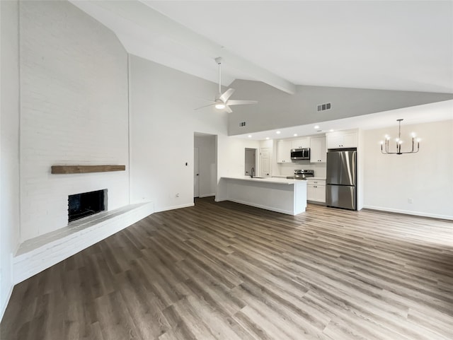 unfurnished living room with sink, light hardwood / wood-style flooring, high vaulted ceiling, a fireplace, and ceiling fan with notable chandelier