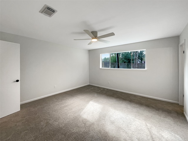 unfurnished room with ceiling fan and dark carpet