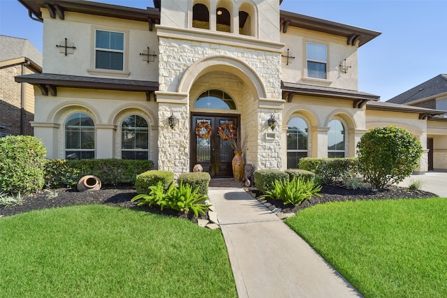 mediterranean / spanish-style house featuring french doors and a front lawn