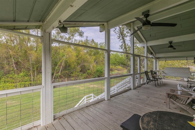 unfurnished sunroom with lofted ceiling with beams and ceiling fan