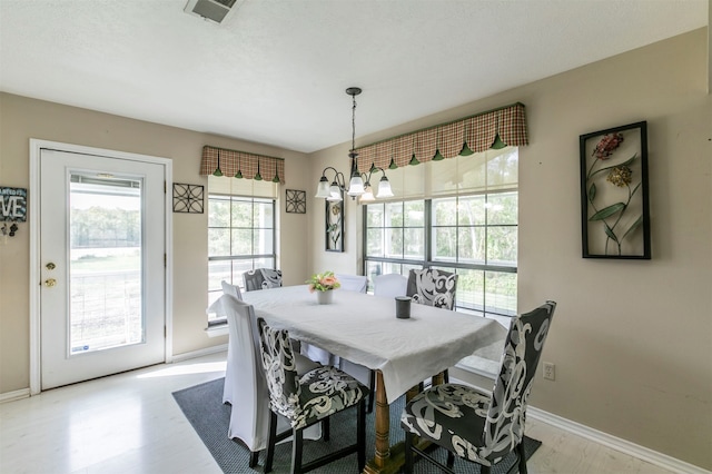 dining room with light hardwood / wood-style flooring and a notable chandelier