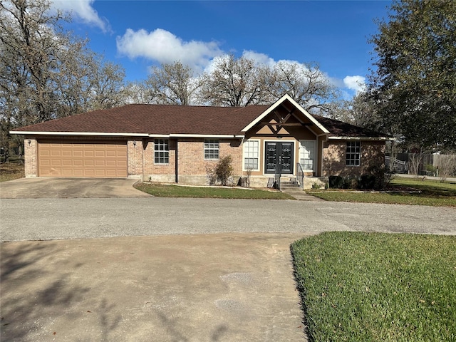 ranch-style home with a front lawn, a garage, and french doors