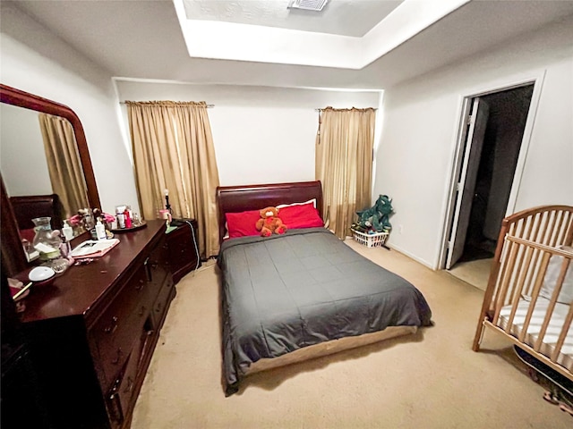 carpeted bedroom with a raised ceiling