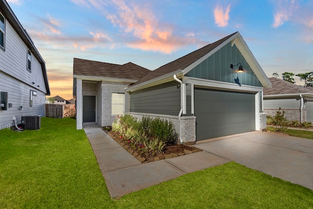 view of front of property featuring a lawn, an outbuilding, cooling unit, and a garage