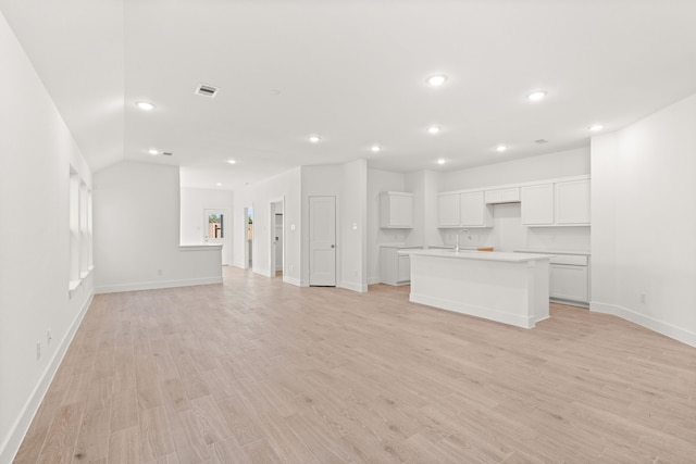 unfurnished living room with sink and light hardwood / wood-style floors