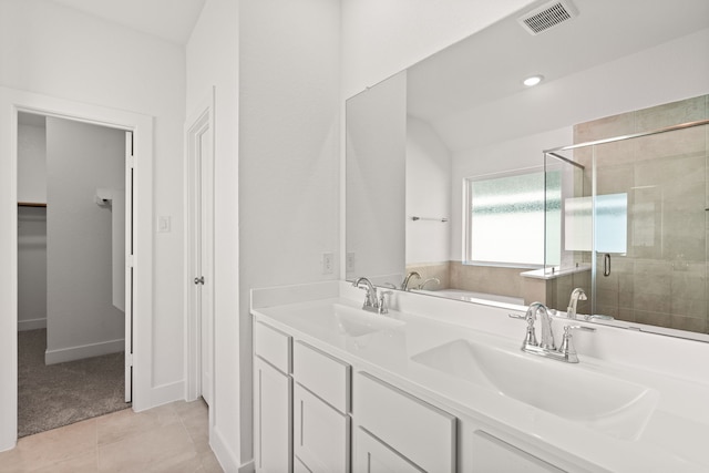 bathroom featuring tile patterned flooring, vanity, and a shower with door