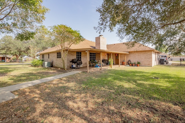 back of property with a lawn, cooling unit, and a patio