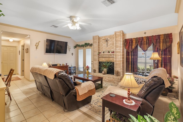 living room with ceiling fan, vaulted ceiling, light tile patterned floors, and a brick fireplace