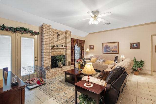 living room featuring ceiling fan, light tile patterned floors, vaulted ceiling, and a brick fireplace