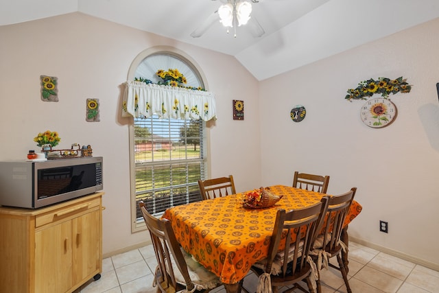 tiled dining space with ceiling fan and lofted ceiling