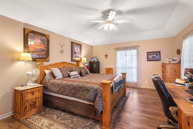 bedroom featuring a textured ceiling, a raised ceiling, ceiling fan, and dark hardwood / wood-style floors