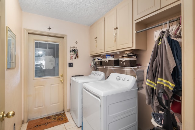 clothes washing area with cabinets, light tile patterned floors, a textured ceiling, and separate washer and dryer