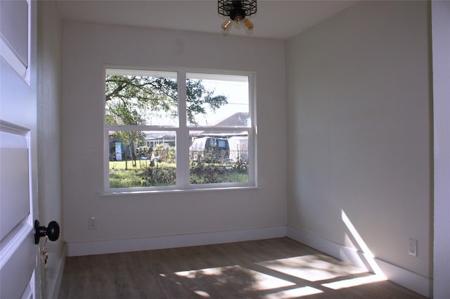 unfurnished room with plenty of natural light and dark hardwood / wood-style flooring