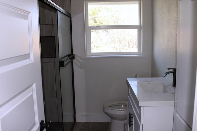 bathroom featuring tile patterned floors, vanity, toilet, and a shower with shower door