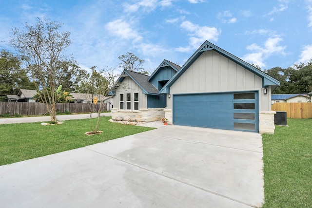 view of front of home with a front yard, a garage, and central air condition unit