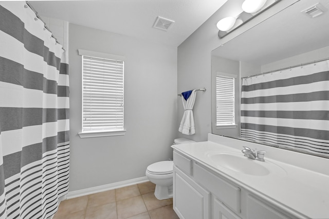 bathroom with tile patterned flooring, plenty of natural light, toilet, and vanity