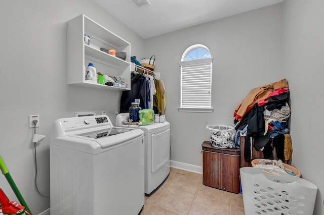 clothes washing area featuring separate washer and dryer and light tile patterned flooring