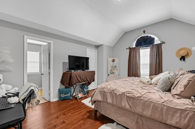 bedroom with hardwood / wood-style floors, lofted ceiling, and multiple windows