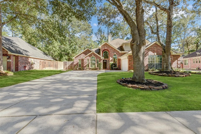 31202 Deerwood Park Ln, Spring City, TX 77386 - traditional-style house featuring concrete driveway, brick siding, an attached garage, and a chimney