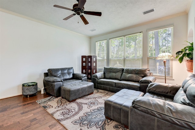 living room with wood-type flooring, a textured ceiling, ceiling fan, and crown molding