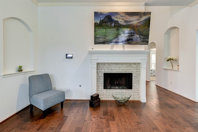 sitting room with crown molding, a fireplace, and hardwood / wood-style flooring