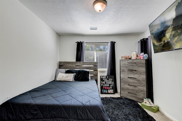 bedroom with carpet flooring and a textured ceiling